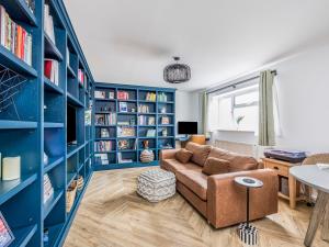a living room with blue bookshelves and a couch at Pass the Keys Stylish Flat Close To Beach in Chichester