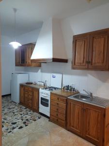 cocina con armarios de madera y horno de fogón blanco en Appartamento Giustenice, en Giustenice