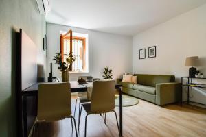 sala de estar con sofá, mesa y sillas en Minisuite Franciacorta en Rovato