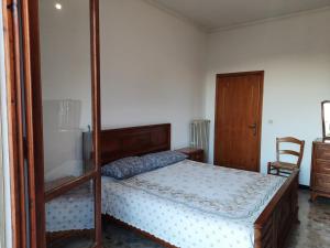 Un dormitorio con una cama con marco de madera. en Appartamento Giustenice, en Giustenice