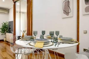 a white table with plates and wine glasses on it at Cozy flat in the center of Madrid-COMEND-3-DE in Madrid