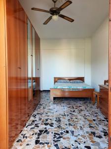 Schlafzimmer mit einem Bett und einem Deckenventilator in der Unterkunft Appartamento Giustenice in Giustenice