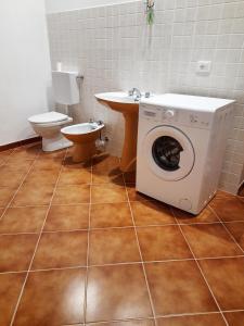 Un baño con lavadora y un inodoro. en Appartamento Giustenice, en Giustenice