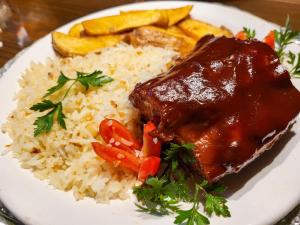 a plate of food with rice and meat and vegetables at Motel Dallas in Belo Horizonte