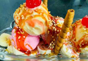 a dessert with ice cream and fruit on a glass plate at Motel Dallas in Belo Horizonte