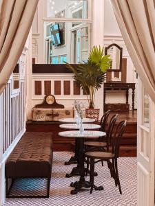 een eetkamer met een tafel en stoelen en een piano bij GRANDE HOTEL PARIS by STAY HOTELS in Porto