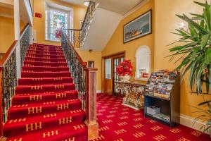 a staircase in a house with a red carpet at Muthu Alexandra Hotel in Oban