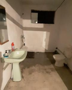 a bathroom with a sink and a toilet at Гостевой дом Жемчужина in Ochamchira