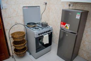 uma cozinha com um fogão e um frigorífico em Classy African - themed 1 BR apartment in Karen em Karen