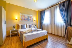 a bedroom with a large bed with blue curtains at Bakbay Otel Bozcaada in Çanakkale