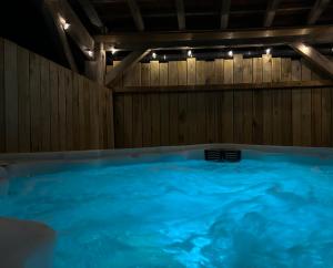 a large swimming pool with blue water in a room at Le Domaine de la Claire Fontaine gites & chambres d'hôtes avec spas privatifs in Montvalent
