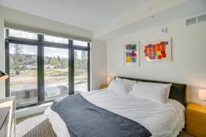 a bedroom with a bed and a large window at Modern Winter Park Condo with Community Hot Tub! in Winter Park