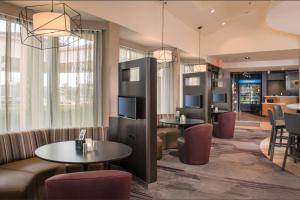 a hotel lobby with tables and chairs and a bar at Courtyard By Marriott Baltimore BWI Airport in Linthicum Heights