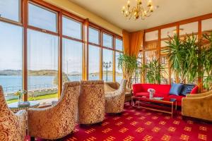 a living room with chairs and a red couch at Muthu Alexandra Hotel in Oban
