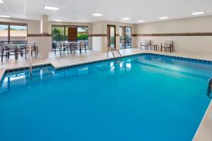 a pool in a hotel room with tables and chairs at Courtyard Bowling Green Convention Center in Bowling Green