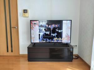 江戸川House（小岩车站400米一户建） في طوكيو: تلفزيون بشاشة مسطحة جالس فوق مركز ترفيه أسود