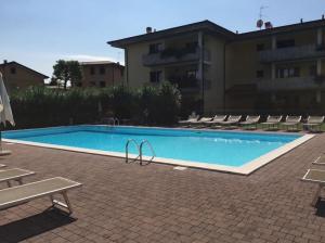 a large swimming pool with chairs and a building at LaMonica.House in Salò