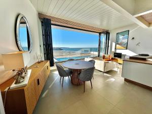 - un salon avec une table et une vue sur l'océan dans l'établissement L'Escale SUNRISE panorama sur l'estuaire, à Royan