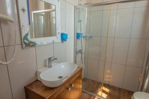 a bathroom with a sink and a shower at Deniz Önü Guesthouse in Ayvalık
