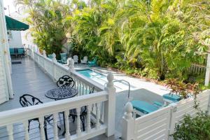 キーウェストにあるSouthernmost Point Guest House & Garden Barのヤシの木とスイミングプール付きのバルコニー