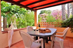a table and chairs on a patio with a bottle of wine at Pinea Mare in Poggio-Mezzana