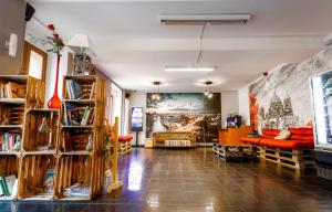 Elle comprend un salon doté d'un mobilier orange et d'une grande peinture murale. dans l'établissement Pegasus Hostel Berlin, à Berlin