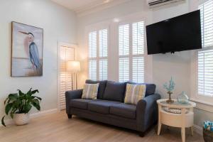 a living room with a couch and a flat screen tv at Southernmost Point Guest House & Garden Bar in Key West