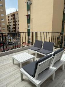 2 sillas y una mesa en el balcón en MALAGA INN APARTAMENTS, en Málaga