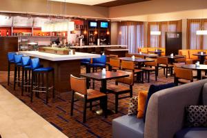 um restaurante com mesas e cadeiras e um bar em Courtyard Chicago Arlington Heights/South em Arlington Heights