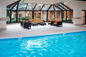 a pool with couches and chairs next to a building at Courtyard Chicago Arlington Heights/South in Arlington Heights