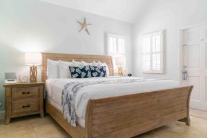 a bedroom with a large bed with a wooden headboard at Southernmost Point Guest House & Garden Bar in Key West