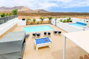 een balkon met 2 zwembaden en een tafeltennistafel bij Villa Bella in Playa Blanca