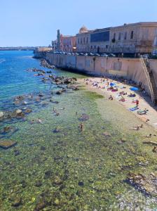 a group of people in the water at a beach at La Casa di Lucia in Syracuse