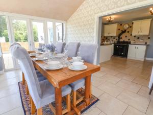 uma cozinha e sala de jantar com uma mesa de madeira e cadeiras em Shire Cottage em Shrewsbury