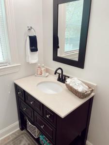 a bathroom with a sink and a mirror at Luxury Home near South Historic District in Coffeyville