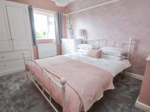 シュルーズベリーにあるShire Cottageのピンクのベッドルーム(ピンクの毛布付きのベッド付)
