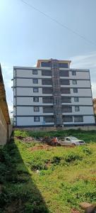 un grande edificio con un'auto parcheggiata di fronte di Akira Safaris Furnished Apartment a Migori