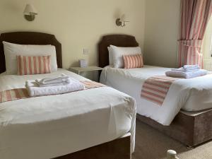 a bedroom with two beds with towels on them at Lubnaig Guest House in Callander