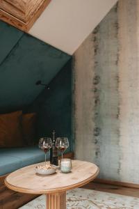 einen Holztisch mit zwei Weingläsern darauf in der Unterkunft Hotel Rosenhof Murau in Murau