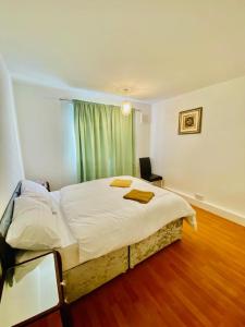 a bedroom with a large white bed with a window at Wonderful Apartment in London in The Hyde