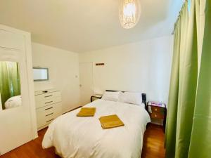 a bedroom with a bed with two towels on it at Wonderful Apartment in London in The Hyde