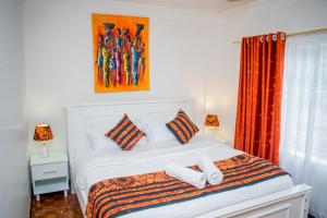 a bedroom with a bed with two towels on it at Classy African - themed 1 BR apartment in Karen in Karen