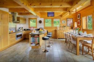 eine Küche mit einem langen Tisch und einem Esszimmer in der Unterkunft Chalet Tolar - OVO Network in Le Grand-Bornand