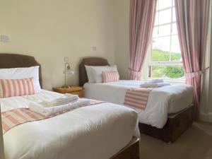 1 dormitorio con 2 camas y ventana en Lubnaig Guest House en Callander