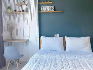 Un dormitorio con una cama con una pared azul y una silla en WINTERFEll HOTEL, en Da Lat