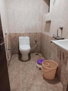 a bathroom with a toilet and a sink at Hotel Neem Tree Hyderabad Airport in Shamshabad