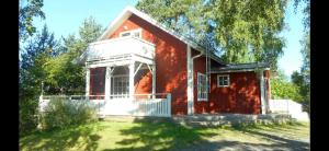 una casa de ladrillo rojo con un porche blanco en un patio en HimosKukkula en Jämsä