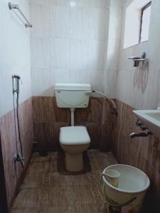 a bathroom with a toilet and a sink at Hotel Neem Tree Hyderabad Airport in Shamshabad