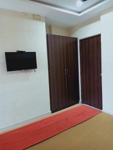 an empty room with two doors and a red rug at Hotel Neem Tree Hyderabad Airport in Shamshabad