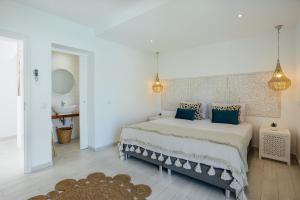 a bedroom with a large bed with blue pillows at Coral Boutique Suites in Albufeira